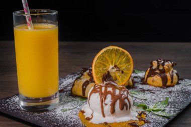 Bir top dondurma bir bardak portakal suyu bir taş zemin üzerine