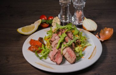 Kavrulmuş et bir kesim ile sebze ahşap arka plan üzerinde kan