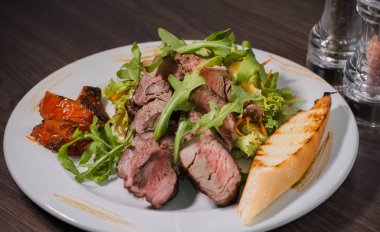 Kavrulmuş et bir kesim ile sebze ahşap arka plan üzerinde kan