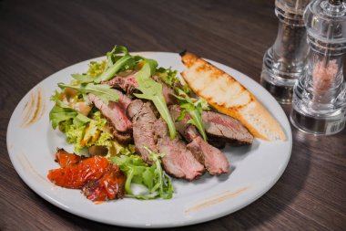 Kavrulmuş et bir kesim ile sebze ahşap arka plan üzerinde kan