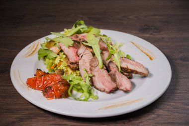 Kavrulmuş et bir kesim ile sebze ahşap arka plan üzerinde kan