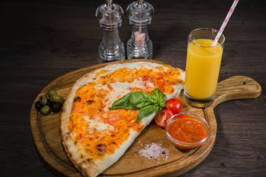 Pizza baharat ve taze meyve suyu ile ahşap bir yüzeye
