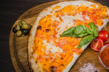 Sıcak parça rustik ahşap bir masa üzerinde erimiş peynirli pizza