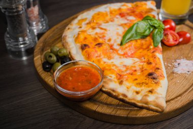 Sıcak parça rustik ahşap bir masa üzerinde erimiş peynirli pizza