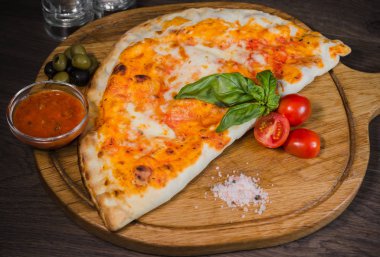 Sıcak parça rustik ahşap bir masa üzerinde erimiş peynirli pizza