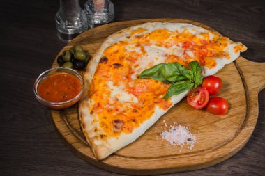 Sıcak parça rustik ahşap bir masa üzerinde erimiş peynirli pizza