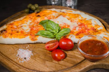 Sıcak parça rustik ahşap bir masa üzerinde erimiş peynirli pizza