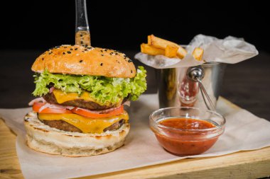 Burger patates kızartması ve domates sosu bir ahşap stand