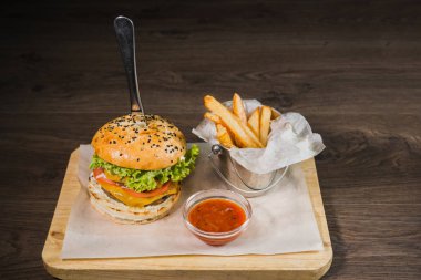 Burger patates kızartması ve domates sosu bir ahşap stand
