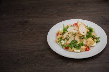 Sezar salatası ahşap arka plan üzerinde beyaz bir tabak içinde