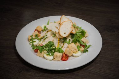 Sezar salatası ahşap arka plan üzerinde beyaz bir tabak içinde