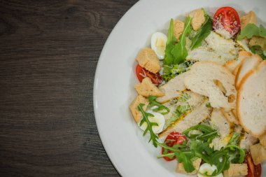 Sezar salatası ahşap arka plan üzerinde beyaz bir tabak içinde