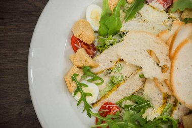 Sezar salatası ahşap arka plan üzerinde beyaz bir tabak içinde