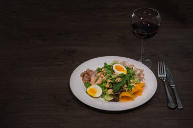 Yumurta ve beyaz bir tabak ve ahşap arka plan üzerinde mantar salatası