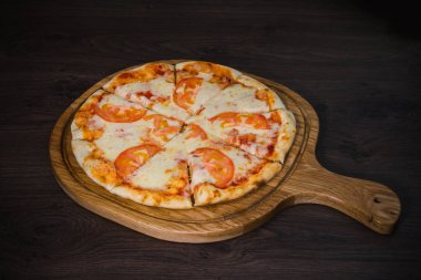Sıcak parça rustik ahşap bir masa üzerinde erimiş peynirli pizza