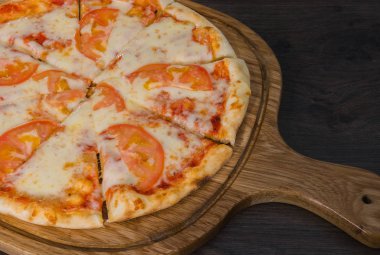 Sıcak parça rustik ahşap bir masa üzerinde erimiş peynirli pizza