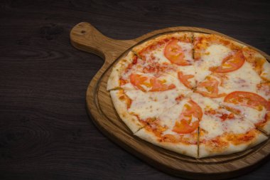 Sıcak parça rustik ahşap bir masa üzerinde erimiş peynirli pizza