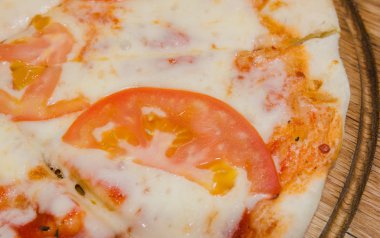 Sıcak parça rustik ahşap bir masa üzerinde erimiş peynirli pizza