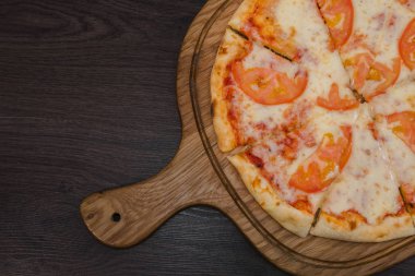 Sıcak parça rustik ahşap bir masa üzerinde erimiş peynirli pizza