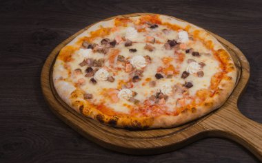 Sıcak parça rustik ahşap bir masa üzerinde erimiş peynirli pizza