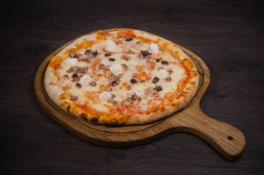 Sıcak parça rustik ahşap bir masa üzerinde erimiş peynirli pizza