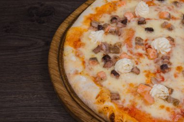Sıcak parça rustik ahşap bir masa üzerinde erimiş peynirli pizza