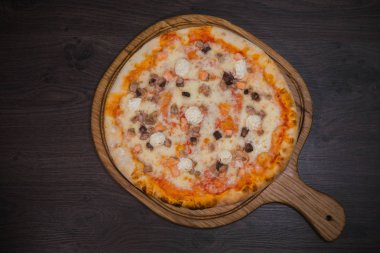 Sıcak parça rustik ahşap bir masa üzerinde erimiş peynirli pizza
