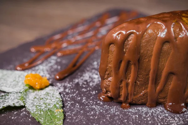 Ahşap arka plan üzerinde turuncu fişle çikolata tatlı — Stok fotoğraf