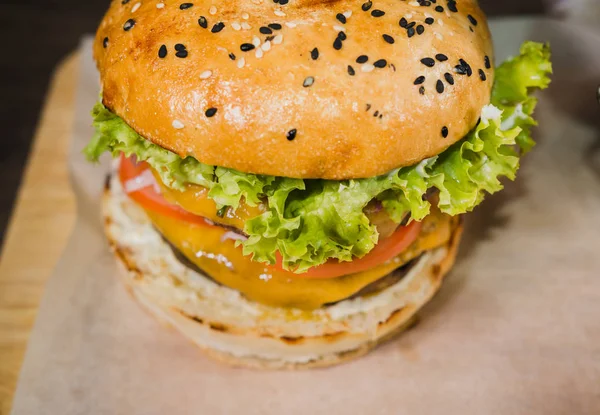 Burger mit Bratkartoffeln und Tomatensauce auf einem Holzständer — Stockfoto