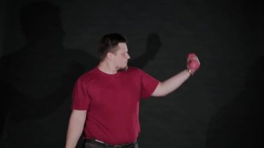 Genç bir adam beceriksizce dambıllarla antrenman yapıyor..