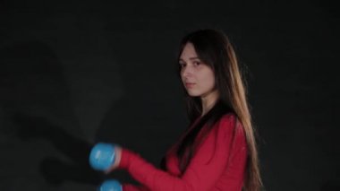 Güzel kız dambıllarla çalışıyor..