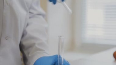 Laboratuvarda deney tüpleri olan bir erkek bilim adamı bir deney yapıyor..