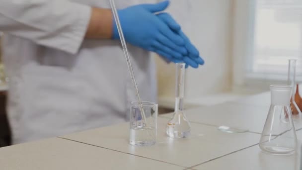Científico masculino con tubos de ensayo en un laboratorio realiza un experimento . — Vídeo de stock