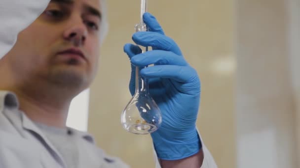 Férfi tudós kémcsövek egy laboratóriumban végez egy kísérletet. — Stock videók