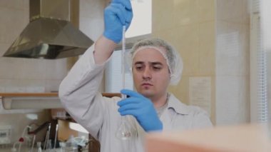 Laboratuvarda deney tüpleri olan bir erkek bilim adamı bir deney yapıyor..