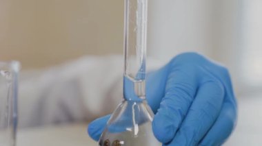 Laboratuvarda deney tüpleri olan bir erkek bilim adamı bir deney yapıyor..