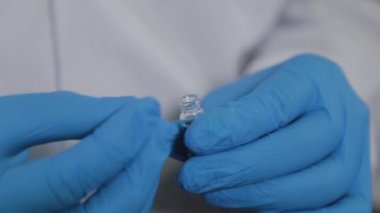 Bilim adamı test tüpünü numuneyle kapatıyor.