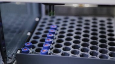 Bir analiz cihazı, sıvının bileşimini incelemek için laboratuvarda çalışır..