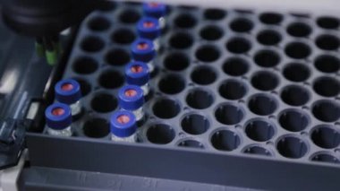 Bir analiz cihazı, sıvının bileşimini incelemek için laboratuvarda çalışır..