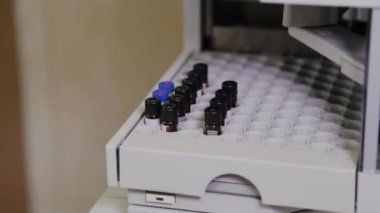 Bir analiz cihazı, sıvının bileşimini incelemek için laboratuvarda çalışır..