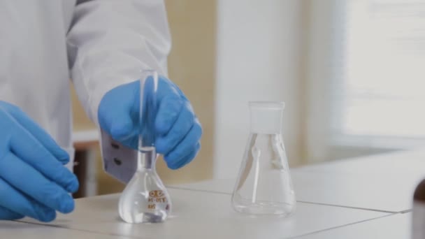 Male scientist with test tubes in a laboratory conducts an experiment. — Stock Video