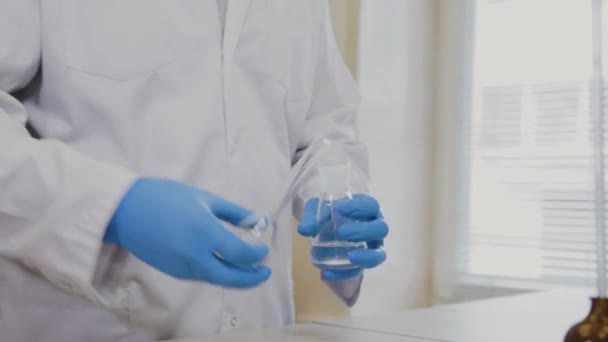 Male scientist with test tubes in a laboratory conducts an experiment. — Stock Video