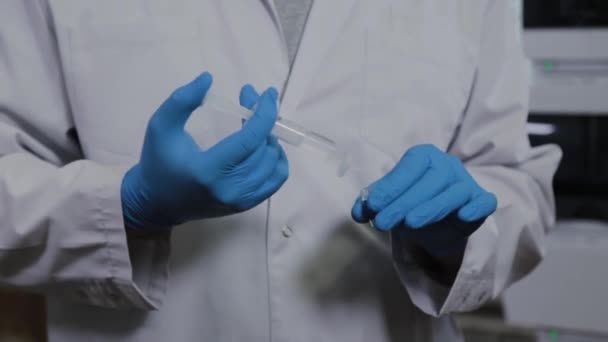 Científico con una jeringa realiza experimentos . — Vídeo de stock