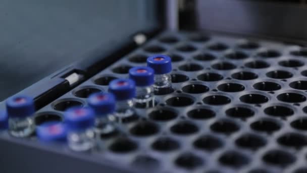 Bir analiz cihazı, sıvının bileşimini incelemek için laboratuvarda çalışır.. — Stok video