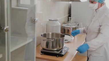 Kadın bilim adamı, ilaç hazırlamak için malzemeleri karıştırıyor..