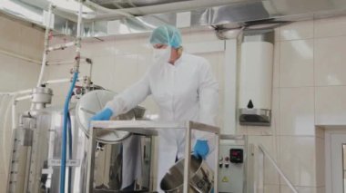 Kadın bilim adamı, ilaçların hazırlanması için reaktöre malzeme koyar..