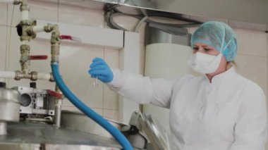 Kadın bilim adamı, ilaçların hazırlanması için reaktöre malzeme koyar..