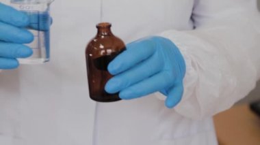 Kadın bilim adamı, ilaç hazırlamak için malzemeleri karıştırıyor..