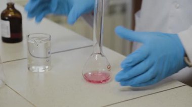 Laboratuvarda deney tüpleri olan bir erkek bilim adamı bir deney yapıyor..