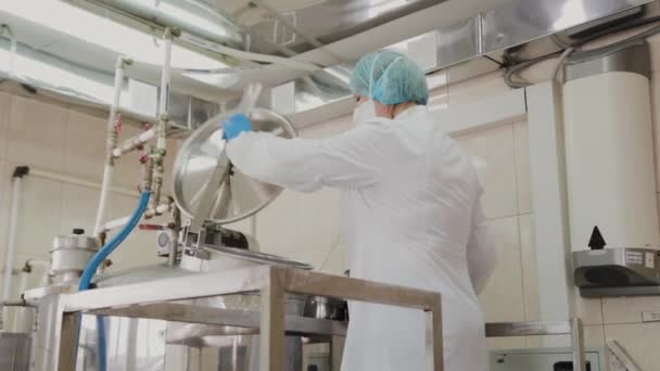 Vrouwelijke wetenschapper stopt ingrediënten in de reactor voor de bereiding van geneesmiddelen. — Stockvideo